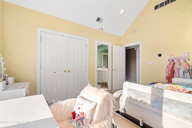 bedroom with connected bathroom, high vaulted ceiling, and a closet