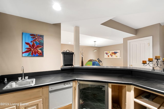 kitchen with pendant lighting, sink, light brown cabinets, and beverage cooler