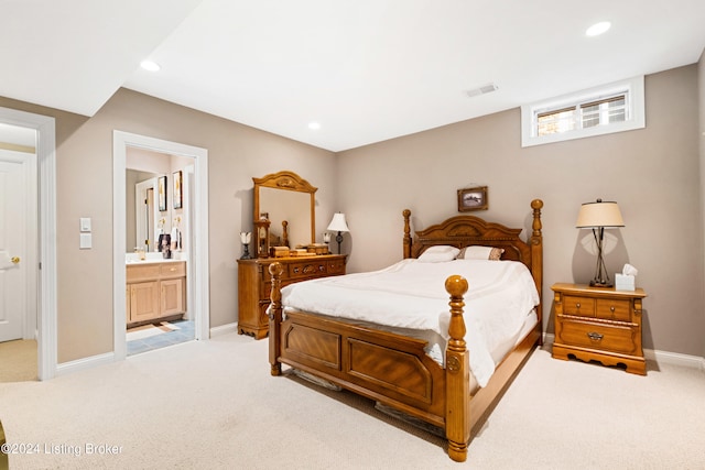 bedroom featuring light carpet, sink, and connected bathroom