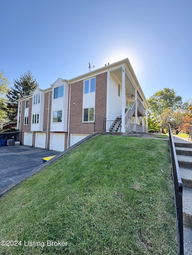 view of property exterior featuring a garage, a yard, and covered porch