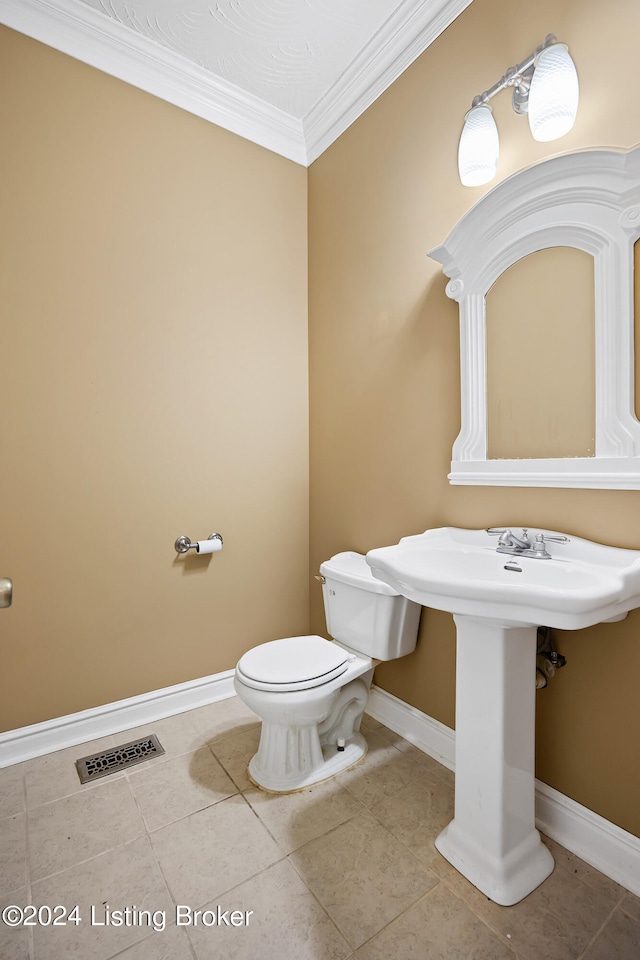 bathroom featuring crown molding, tile patterned floors, and toilet