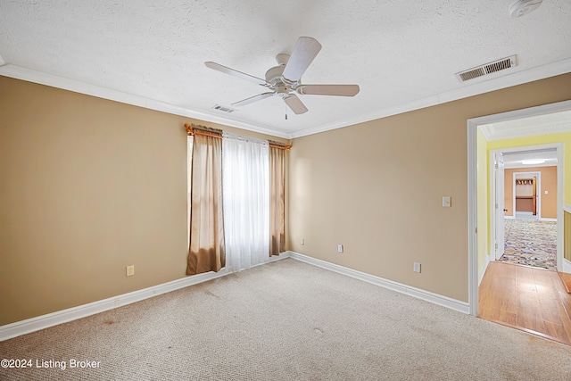 carpeted empty room featuring ceiling fan, a textured ceiling, and crown molding