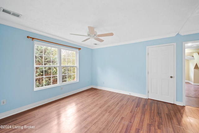 spare room featuring ceiling fan, hardwood / wood-style flooring, and crown molding