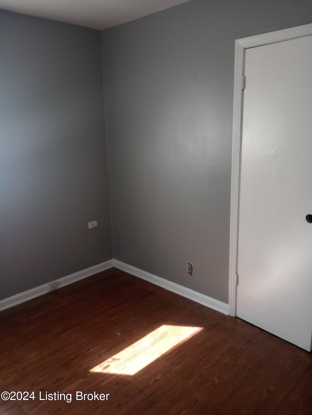 empty room with dark hardwood / wood-style floors