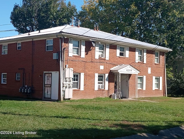 view of front of property with a front yard and cooling unit