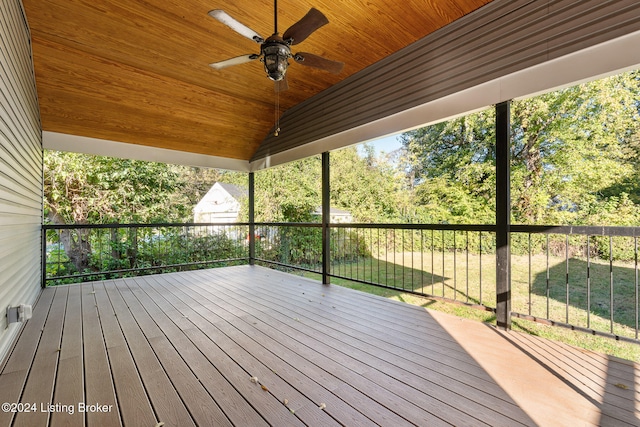 wooden terrace featuring a lawn and ceiling fan