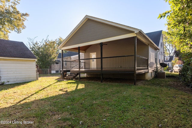 rear view of house featuring a deck and a lawn