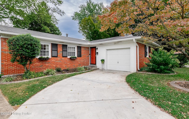 single story home featuring a garage and a front lawn