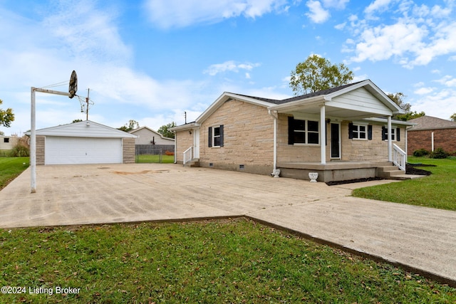 view of front of home with a porch, a front yard, an outbuilding, and a garage