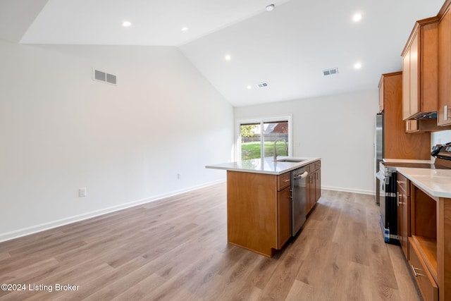 kitchen with a center island with sink, stainless steel appliances, high vaulted ceiling, sink, and light hardwood / wood-style floors