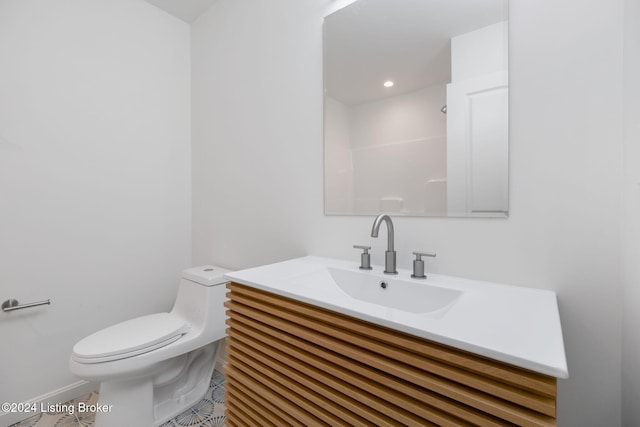 bathroom featuring tile patterned flooring, vanity, toilet, and a shower