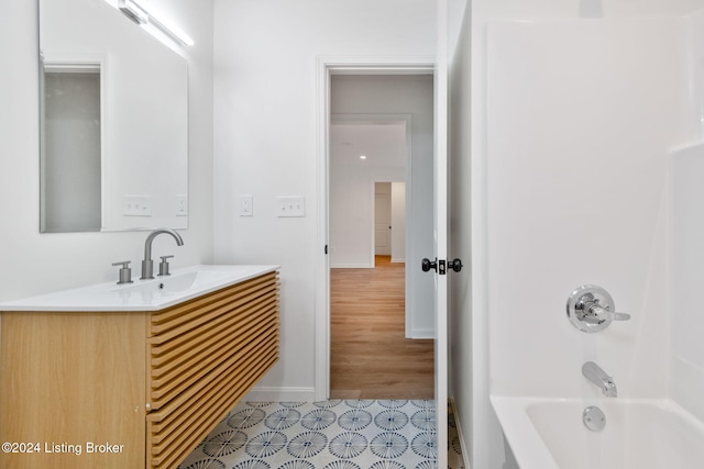 bathroom with shower / bathing tub combination, vanity, and wood-type flooring