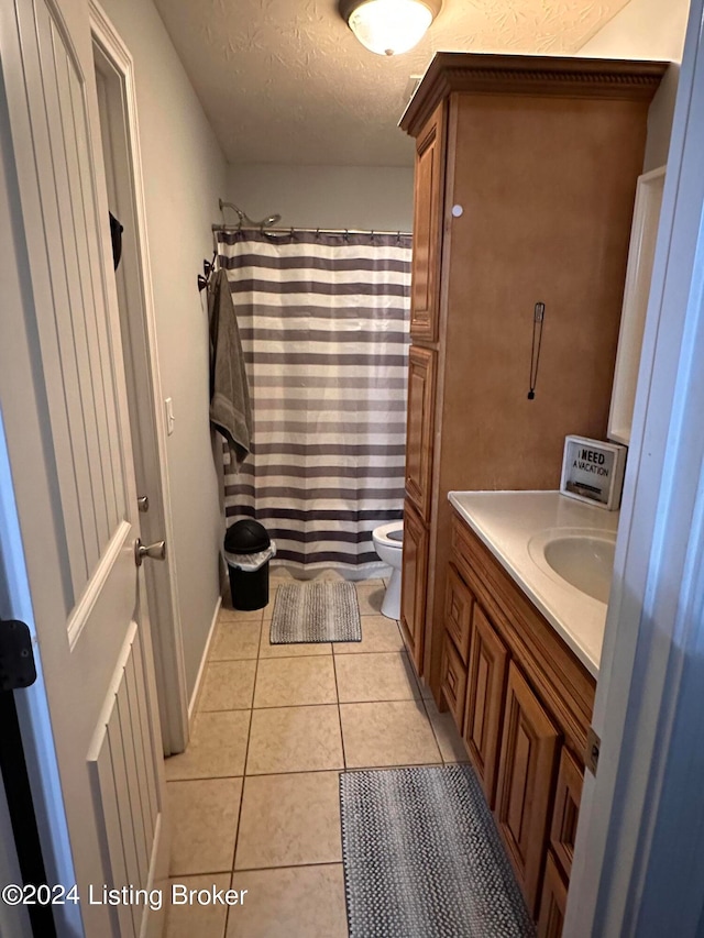 bathroom with vanity, a textured ceiling, tile patterned floors, a shower with curtain, and toilet