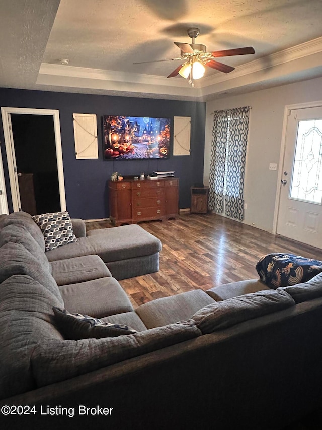 living room featuring ceiling fan, hardwood / wood-style flooring, a raised ceiling, and a textured ceiling