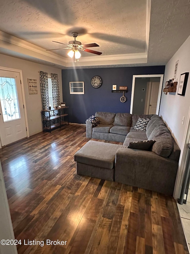 living room with ceiling fan, a textured ceiling, a raised ceiling, and hardwood / wood-style floors