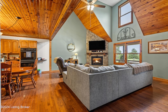 living room featuring ceiling fan, wooden ceiling, a stone fireplace, dark hardwood / wood-style floors, and high vaulted ceiling