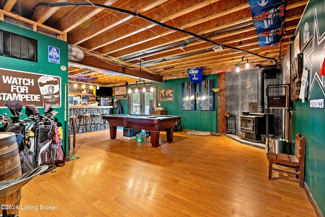 recreation room featuring a wood stove, indoor bar, pool table, and hardwood / wood-style floors