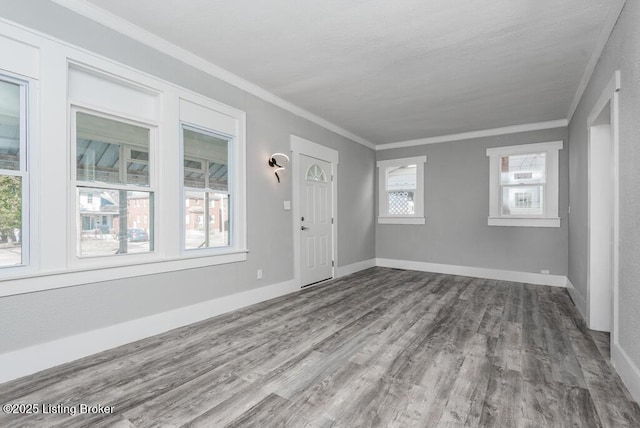 entryway featuring a healthy amount of sunlight, crown molding, baseboards, and wood finished floors