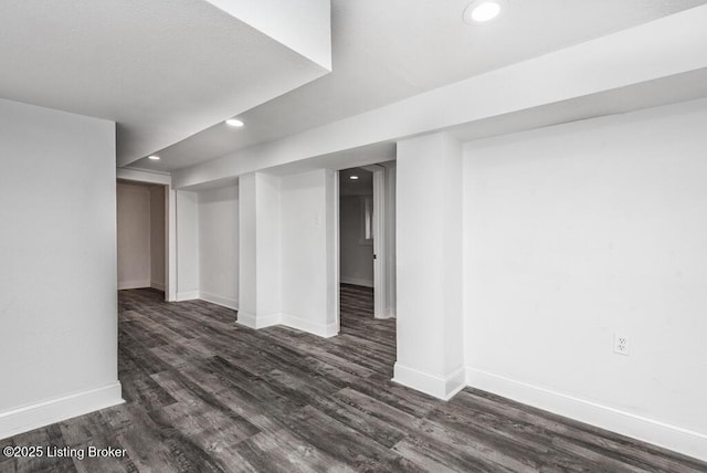 finished below grade area with dark wood-type flooring, recessed lighting, and baseboards