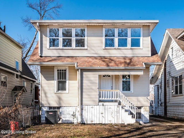 rear view of house featuring a shingled roof, fence, and central AC unit