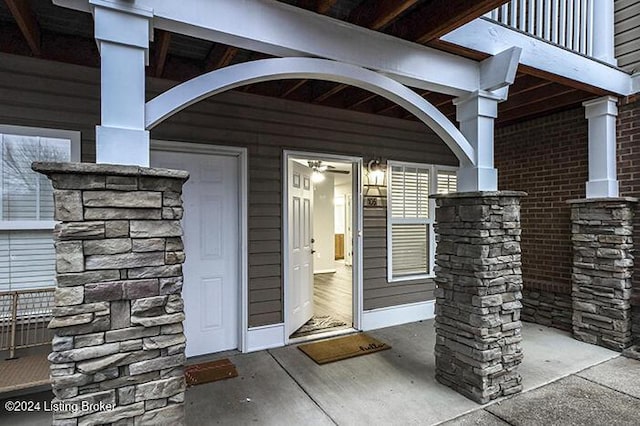 view of exterior entry with a balcony and covered porch