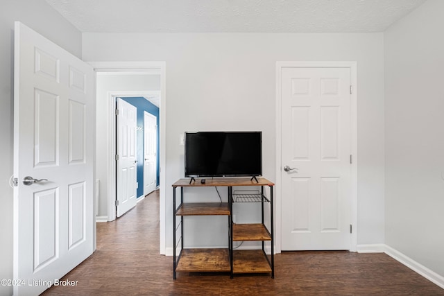 interior space featuring dark wood-type flooring and a textured ceiling