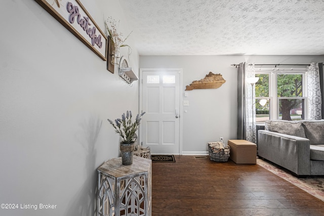 foyer featuring a textured ceiling and dark hardwood / wood-style floors