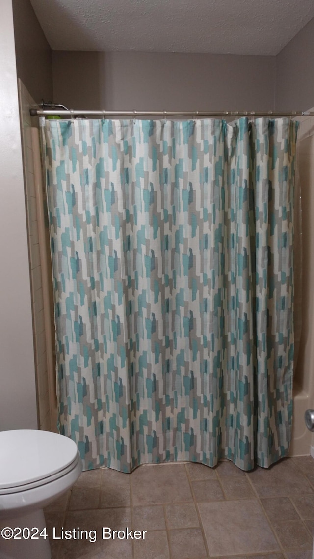 bathroom with toilet and a textured ceiling