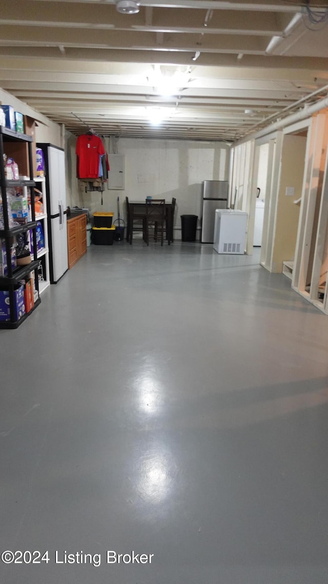 basement featuring stainless steel fridge and electric panel