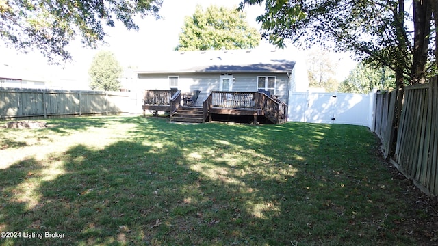 back of property with a wooden deck and a yard