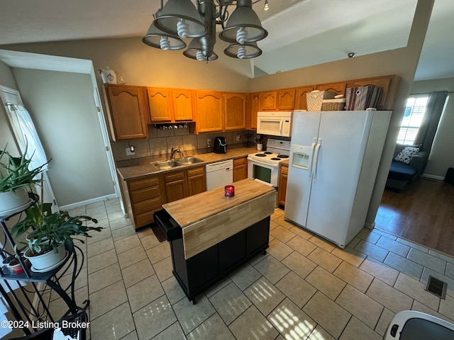 kitchen featuring white appliances, sink, backsplash, light hardwood / wood-style floors, and lofted ceiling