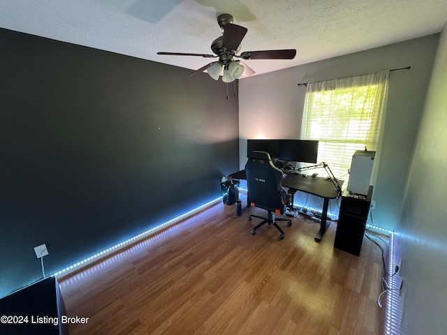 home office featuring a textured ceiling, hardwood / wood-style flooring, and ceiling fan