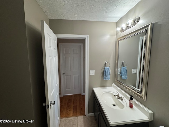 bathroom featuring vanity, a textured ceiling, and wood-type flooring