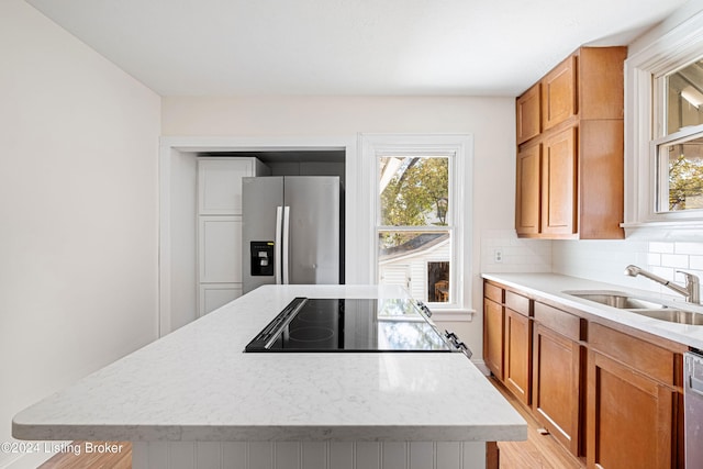 kitchen featuring appliances with stainless steel finishes, tasteful backsplash, sink, and a kitchen island