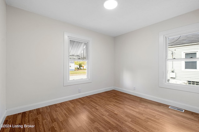 unfurnished room with hardwood / wood-style flooring