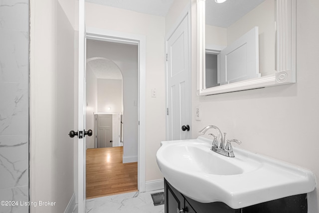 bathroom featuring vanity, a textured ceiling, and wood-type flooring