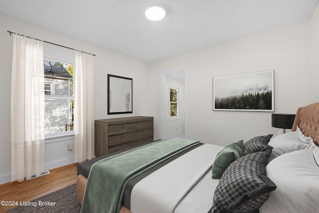 bedroom featuring hardwood / wood-style flooring and multiple windows