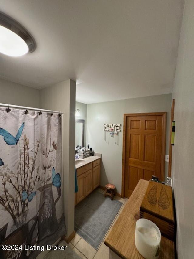 bathroom with a shower with curtain, tile patterned flooring, and vanity