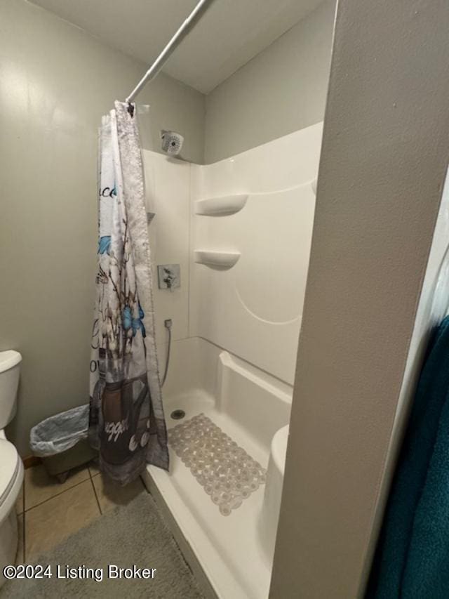 bathroom featuring toilet and a shower with shower curtain