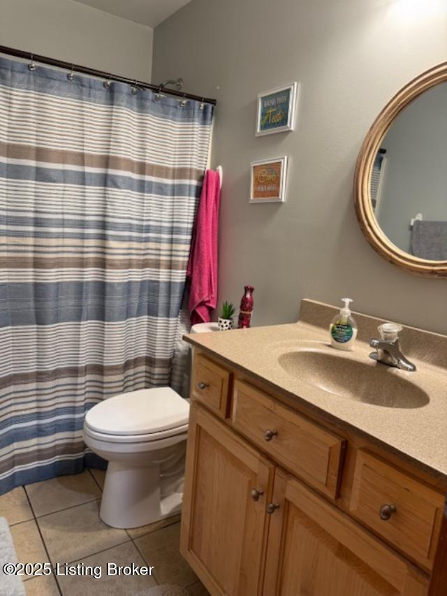 full bath with a shower with curtain, vanity, toilet, and tile patterned floors