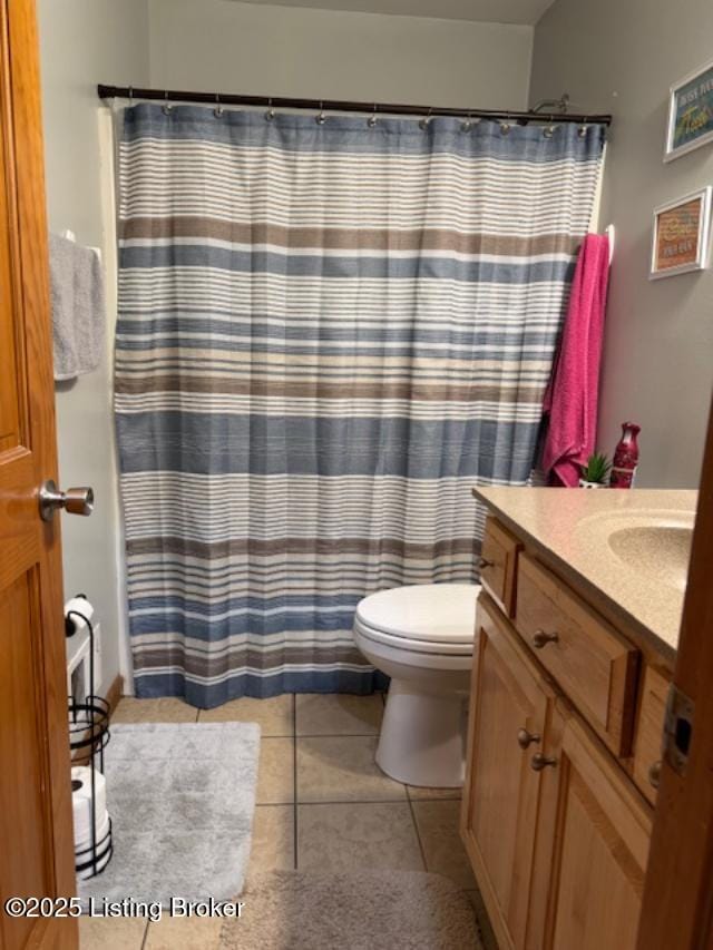 bathroom with curtained shower, vanity, toilet, and tile patterned floors