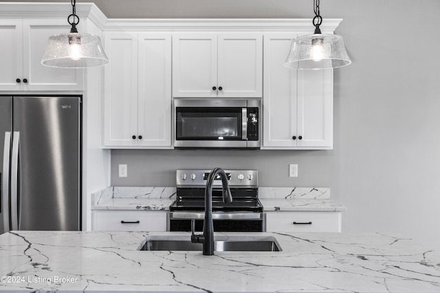 kitchen featuring white cabinets, hanging light fixtures, and stainless steel appliances