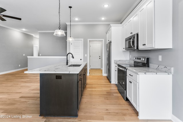 kitchen featuring white cabinetry, appliances with stainless steel finishes, sink, and a kitchen island with sink