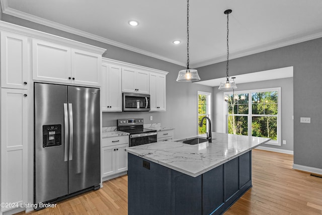 kitchen with light hardwood / wood-style flooring, a center island with sink, sink, white cabinets, and appliances with stainless steel finishes