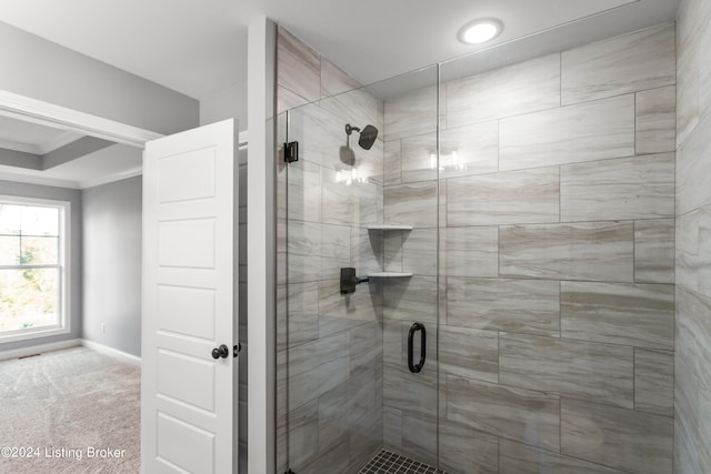 bathroom featuring a shower with door and crown molding