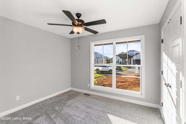 spare room with carpet flooring and ceiling fan