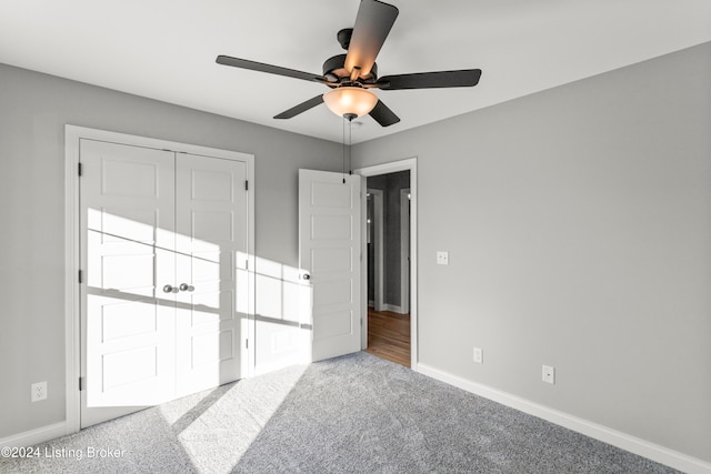 unfurnished bedroom with light colored carpet, a closet, and ceiling fan