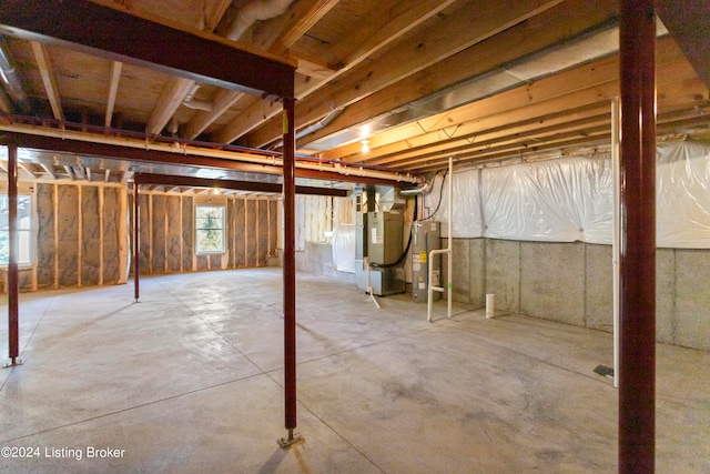 basement with electric water heater and heating unit