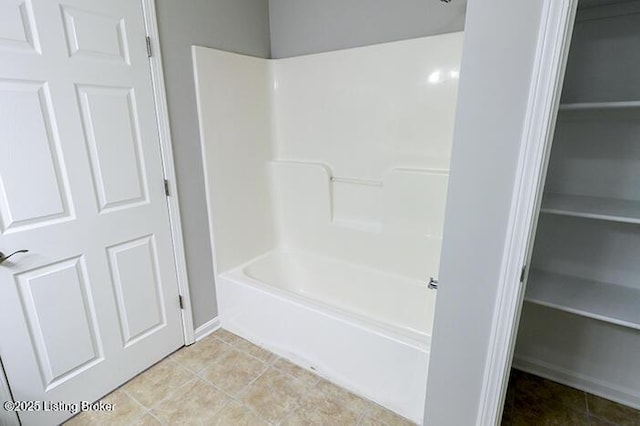 bathroom with bathing tub / shower combination and tile patterned floors