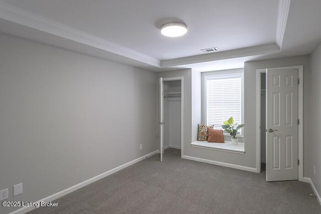 unfurnished bedroom featuring a raised ceiling and carpet floors